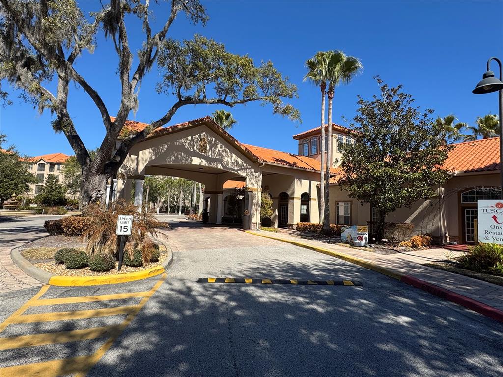 A paved driveway leads to a covered entrance of a building with a tile roof — 1301 TUSCAN TERRACE UNIT 9301, DAVENPORT, FL
