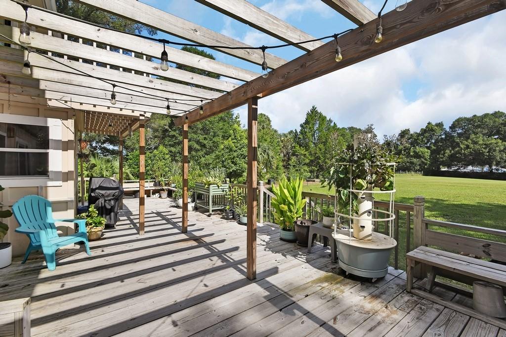 A wooden deck features a pergola with string lights, a vertical garden, and outdoor seating — 1379 TAYLOR ROAD W, DELAND, FL