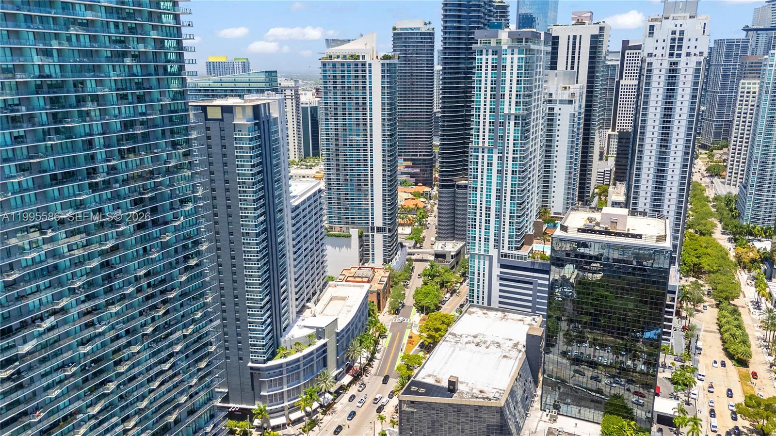 An aerial view shows multiple high-rise apartment buildings and city streets in a dense urban area — 1250 S Miami Ave # 3506, Miami FL 33130, MIAMI, FL