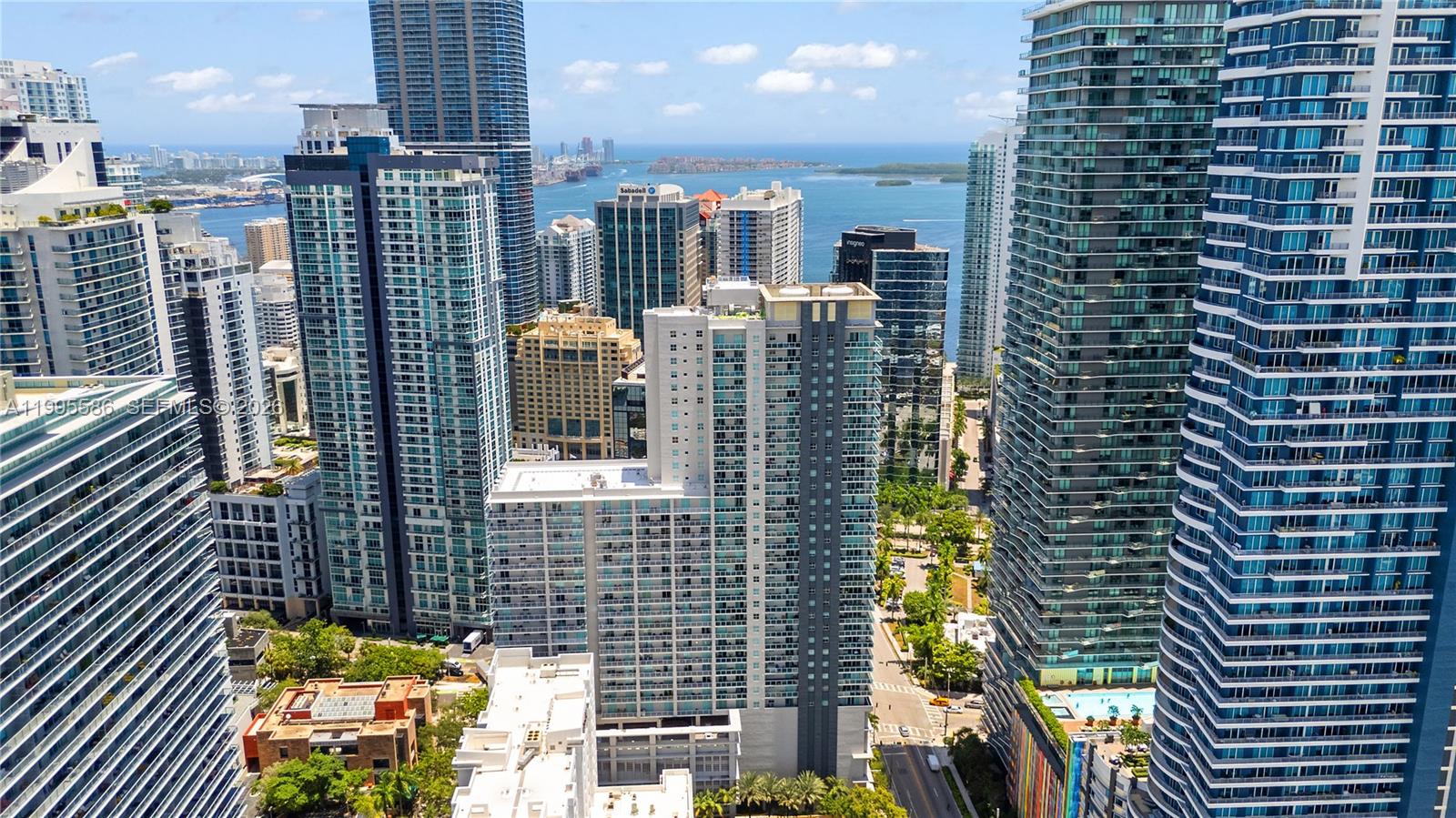 An aerial view shows a dense urban landscape of modern high-rise buildings near the ocean — 1250 S Miami Ave # 3506, Miami FL 33130, MIAMI, FL