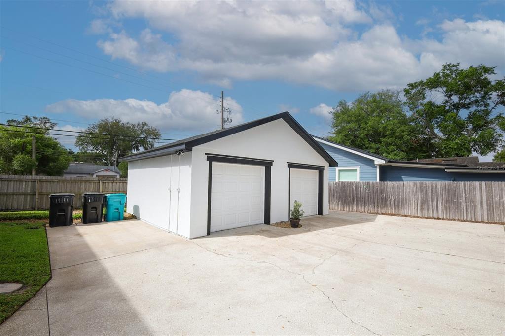 A covered porch features a black front door, two wooden chairs, and white exterior walls — 2202 ELIZABETH AVENUE UNIT B, ORLANDO, FL