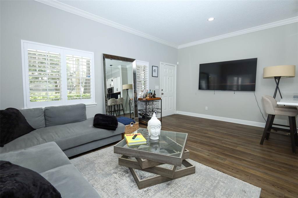 A living room features a gray sectional sofa, a glass coffee table, and a large mirror — 2202 ELIZABETH AVENUE UNIT B, ORLANDO, FL