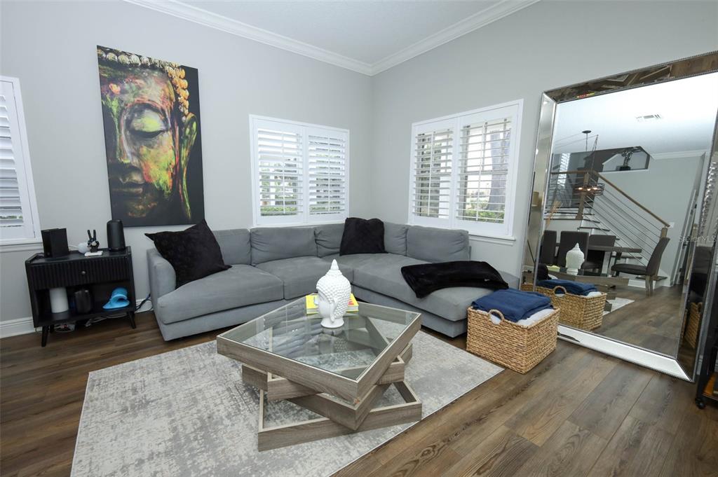 A living room features a grey sectional sofa, glass coffee table, and wall-mounted television — 2202 ELIZABETH AVENUE UNIT B, ORLANDO, FL