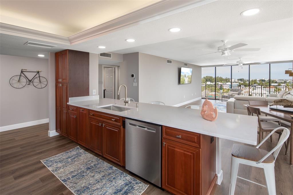 A kitchen with wood cabinets, a white countertop, and a stainless steel dishwasher — 7650 BAYSHORE DRIVE UNIT 606, TREASURE ISLAND, FL