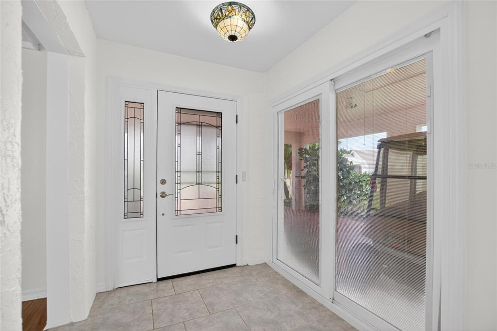An entryway features a white front door with glass panels, tile flooring, and sliding doors — 213 GLENELLEN PLACE, SUN CITY CENTER, FL