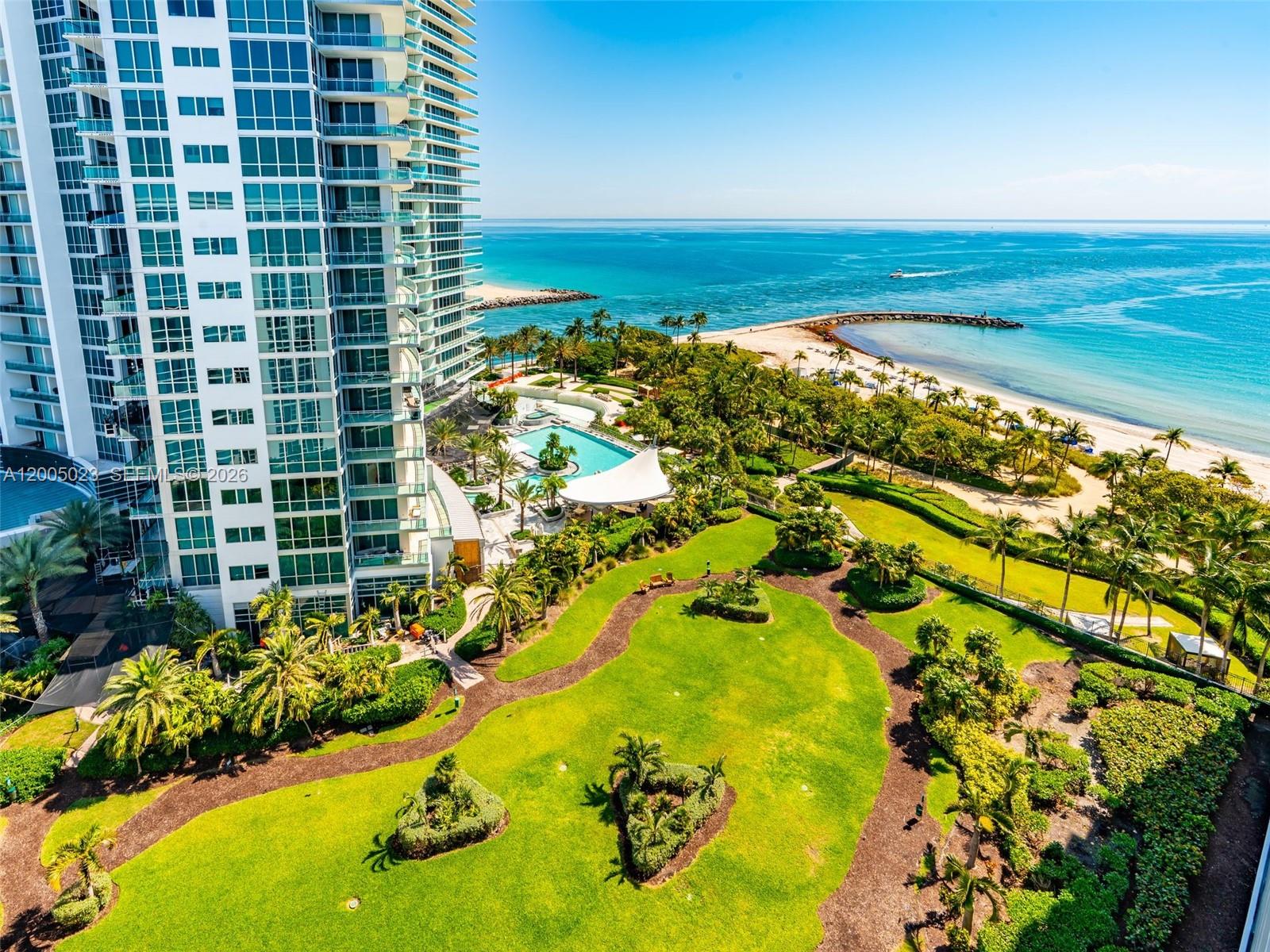 An aerial view shows a high-rise building next to a landscaped lawn and beach — 10275 Collins Ave # 1502, Bal Harbour FL 33154, BAL HARBOUR, FL