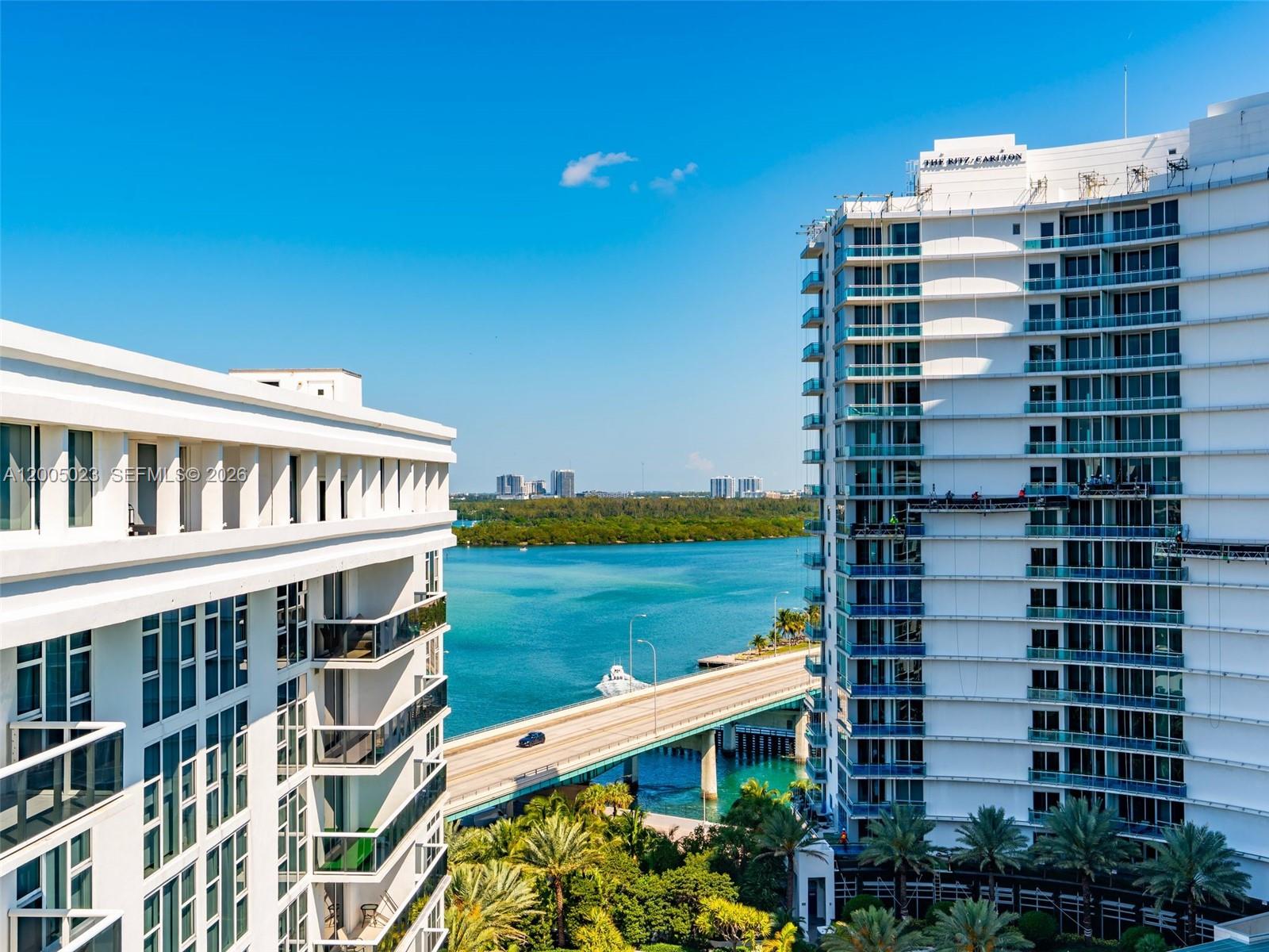 An exterior view shows two high-rise buildings separated by a bridge over blue water — 10275 Collins Ave # 1502, Bal Harbour FL 33154, BAL HARBOUR, FL
