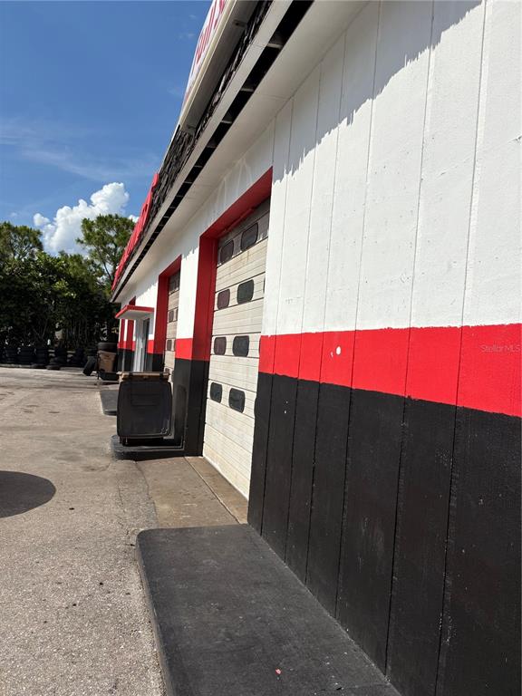 An exterior view of a commercial building with white, red, and black painted walls — 1308 TAMIAMI TRAIL, PUNTA GORDA, FL