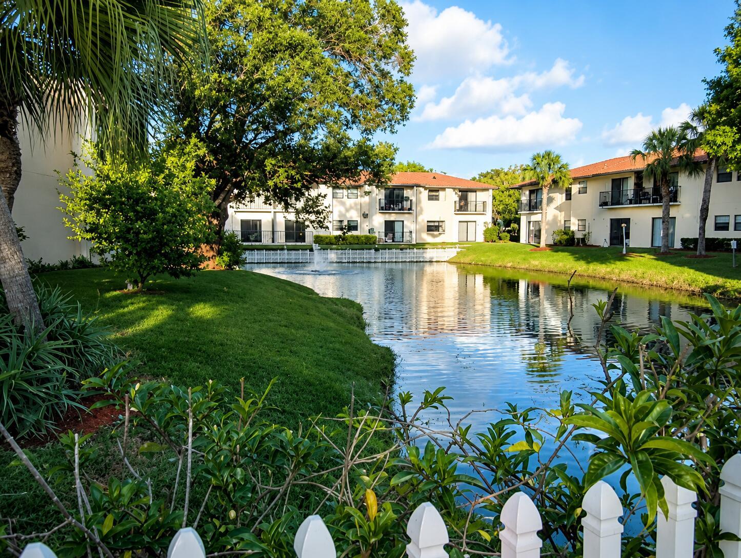 A pond with a fountain sits in front of multi-story apartment buildings and green lawns — 2050 Oleander Boulevard # 105, Fort Pierce FL 34950, FORT PIERCE, FL