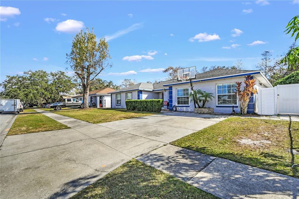 A single-story house with a concrete driveway, a basketball hoop, and a white privacy fence — 362 IOWA WOODS CIRCLE W, ORLANDO, FL