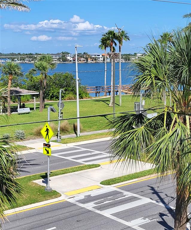 A view of a waterfront park with a crosswalk, palm trees, and a wooden pier — 17960 GULF BOULEVARD UNIT 101, REDINGTON SHORES, FL