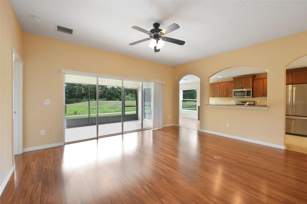 A dining area with wood flooring and a chandelier next to a tiled entryway — 4025 ARLINGTON RIDGE BOULEVARD, LEESBURG, FL
