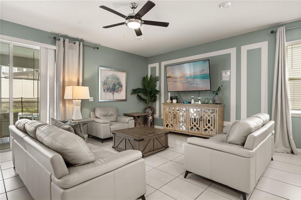 A living room features light gray leather furniture, a wooden coffee table, and a television console — 2036 LELANI CIR, DAVENPORT, FL