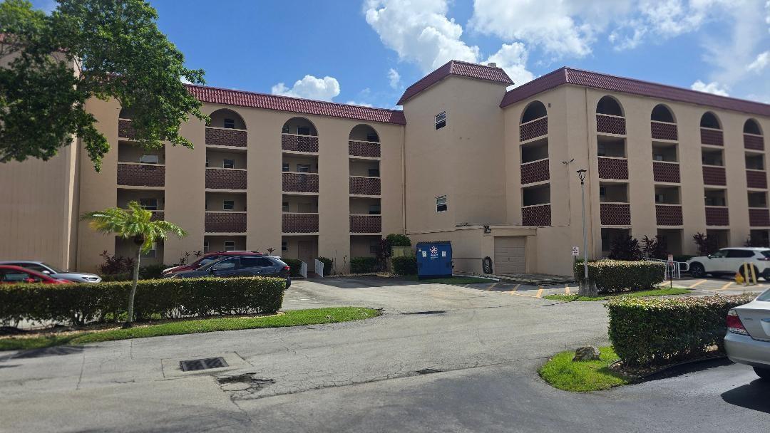 A multi-story apartment building with a tan stucco exterior and a red tile roof — 3251 Holiday Springs Boulevard # 302, Margate FL 33063, MARGATE, FL