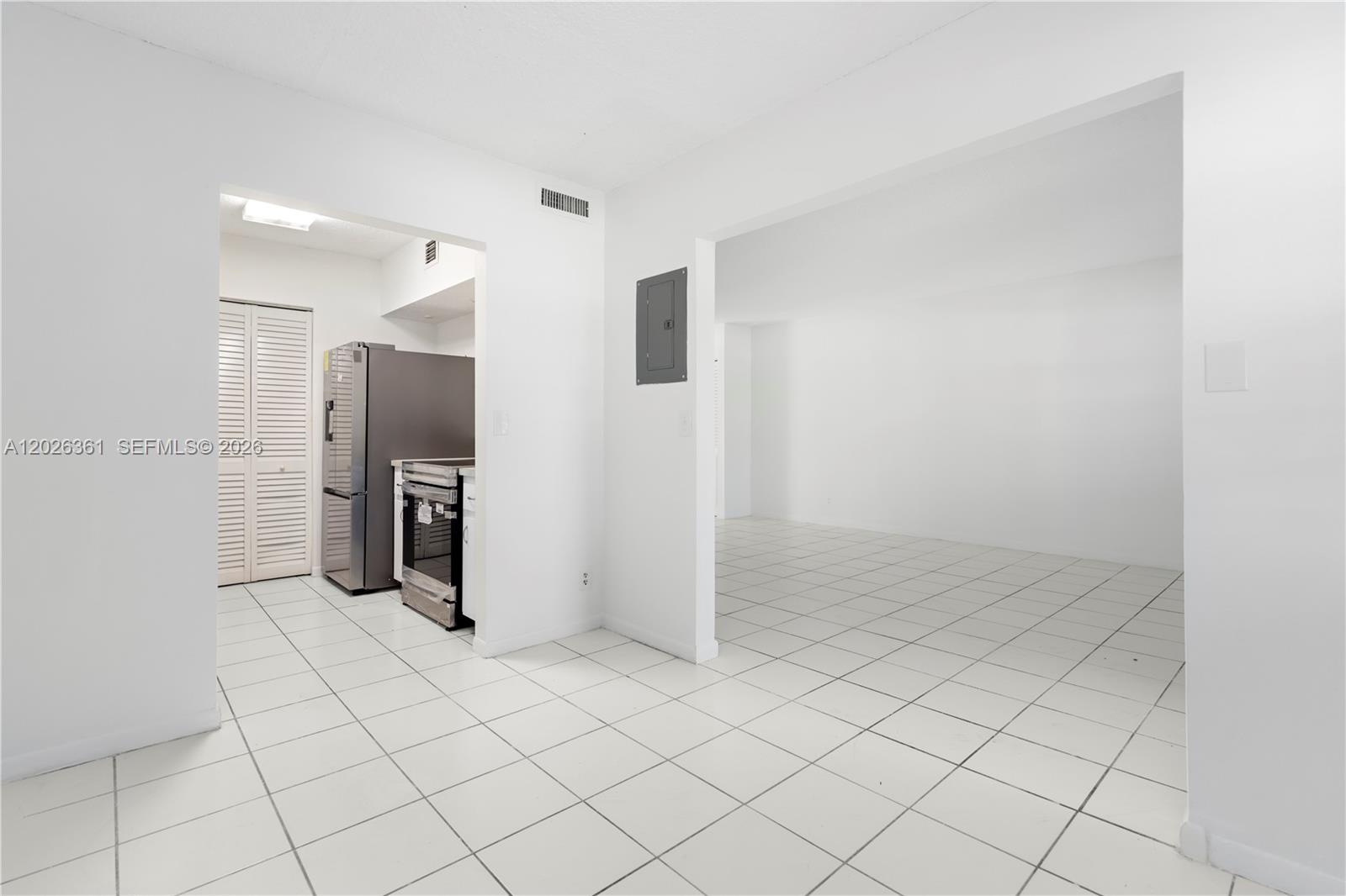 A kitchen with stainless steel appliances opens into a tiled living area with white walls — 500 NE 2nd St # 223, Dania Beach FL 33004, DANIA BEACH, FL