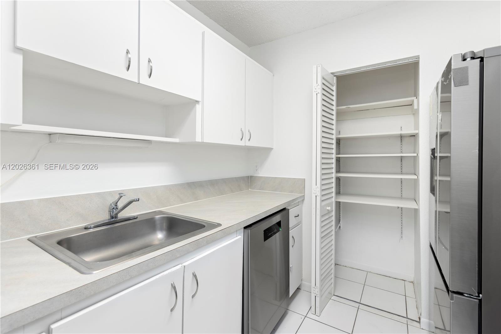A kitchen features white cabinets, a stainless steel dishwasher, a sink, and a pantry closet — 500 NE 2nd St # 223, Dania Beach FL 33004, DANIA BEACH, FL