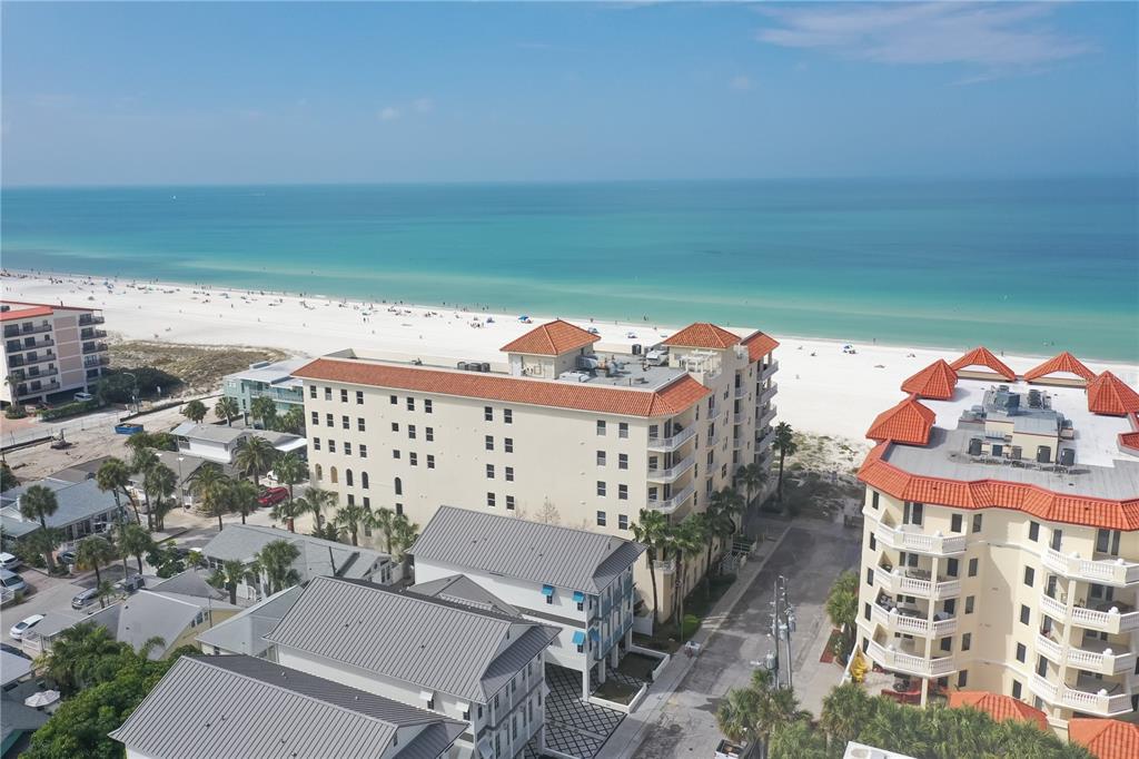 An aerial view shows multi-story buildings near a white sand beach and the ocean — 15 SOMERSET STREET UNIT 603, CLEARWATER BEACH, FL