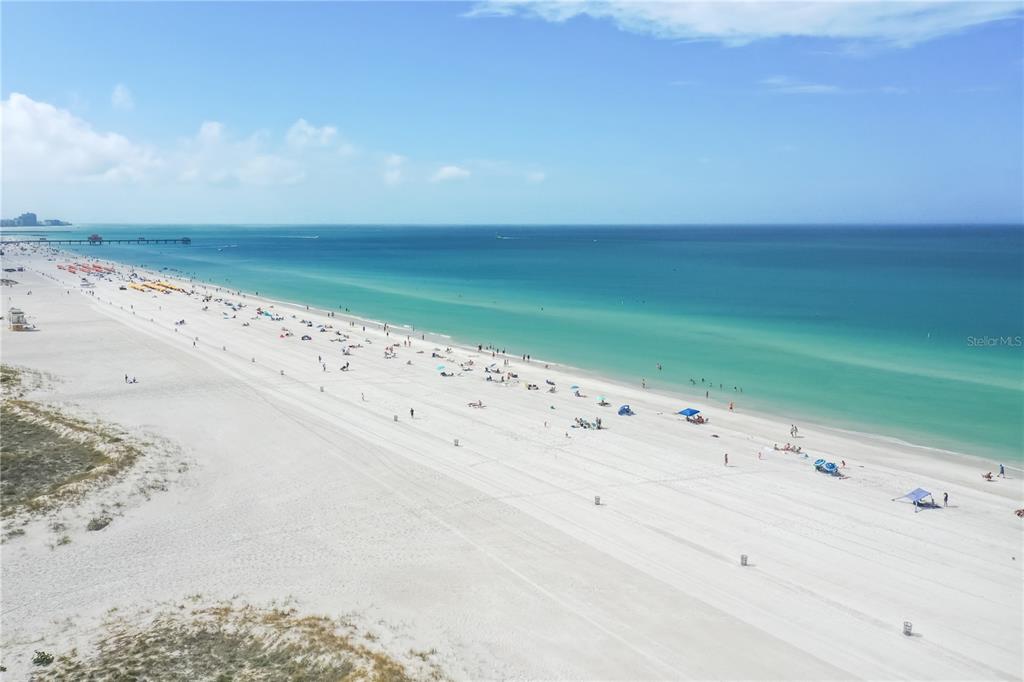 An aerial view of a wide, sandy beach along a turquoise ocean under a blue sky — 15 SOMERSET STREET UNIT 603, CLEARWATER BEACH, FL