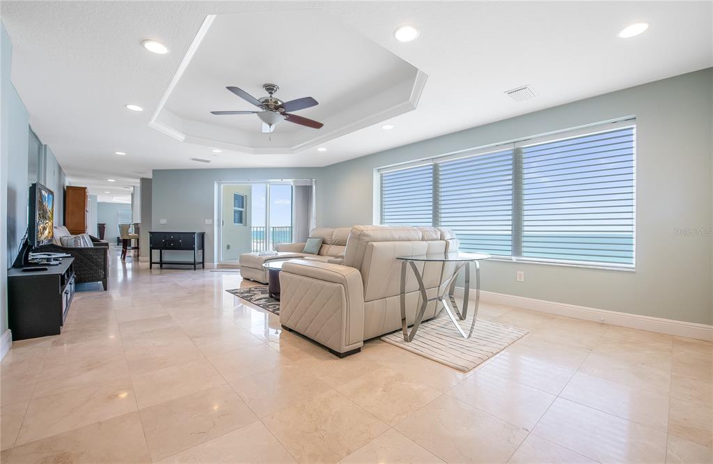 A spacious living room features light tile floors, a tray ceiling, and large ocean-view windows — 15 SOMERSET STREET UNIT 603, CLEARWATER BEACH, FL