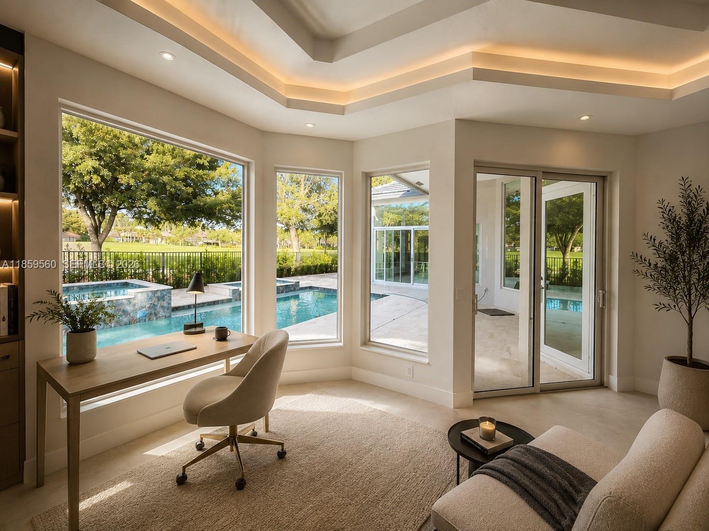 A home office with a desk, chair, and sofa overlooking a pool through large windows — 2523 Montclaire Cir, Weston FL 33327, WESTON, FL