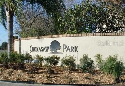 A beige stucco wall with the text Chickasaw Park and a tree silhouette logo — SUBURBAN DRIVE, ORLANDO, FL