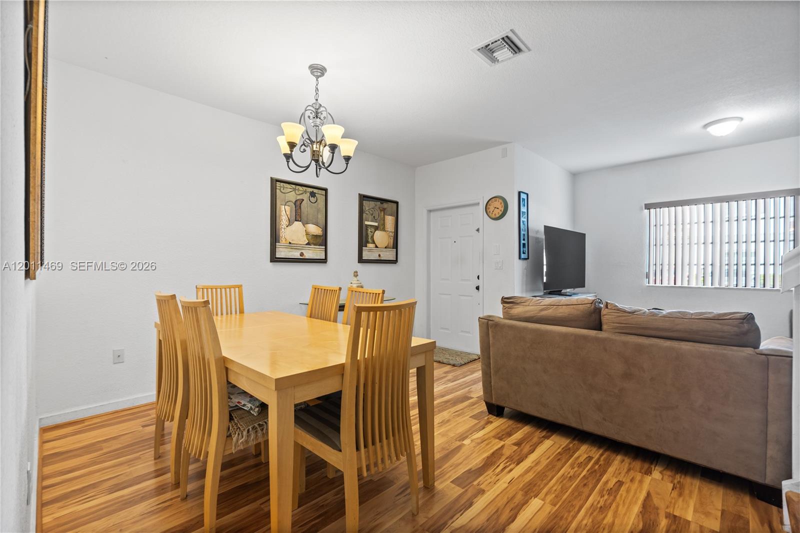 A dining area with a wooden table and chairs sits adjacent to a living room — 8430 SW 150th Ave # 2, Miami FL 33193, MIAMI, FL