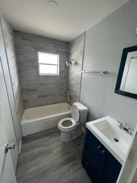 A bathroom features a tiled tub-shower combo, a white toilet, and a navy blue vanity — 13106 LEISUREWOOD PLACE UNIT 102, TAMPA, FL