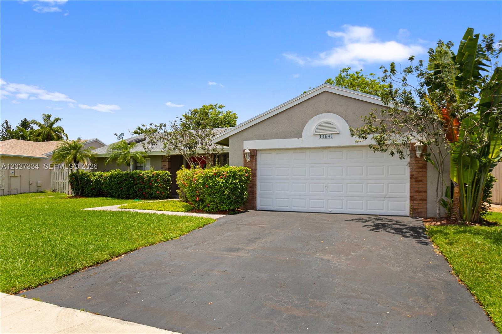 A single-story house features a gray exterior, a white garage door, and a manicured hedge — 14641 Kirsten Ct, Davie FL 33325, DAVIE, FL