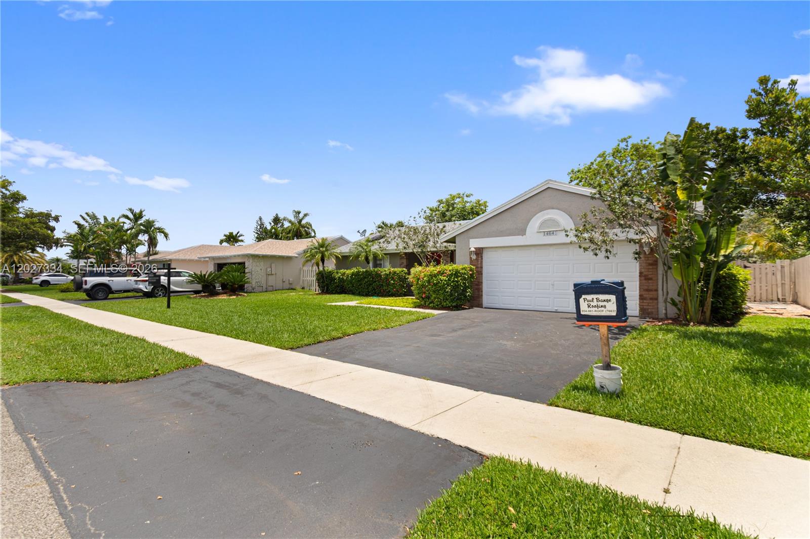 A covered porch features a bright red double front door with wreaths and brick pillars — 14641 Kirsten Ct, Davie FL 33325, DAVIE, FL