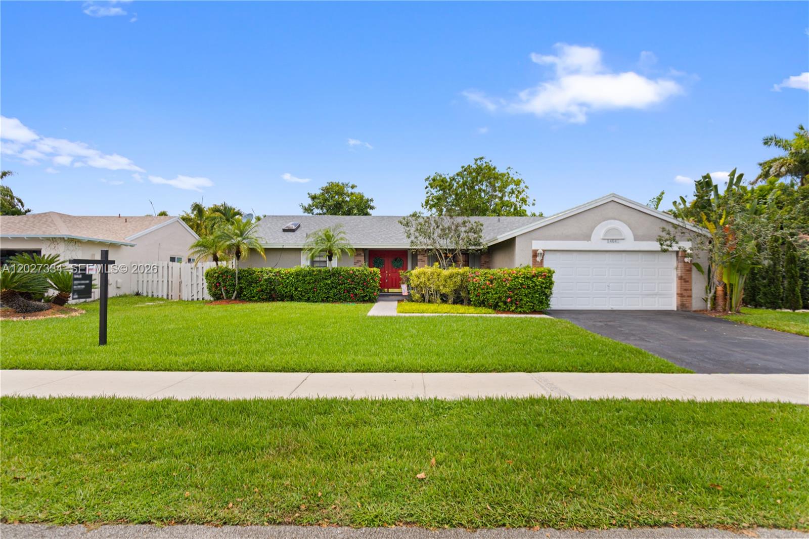 A covered front porch features a white metal bench, brick columns, and a small garden — 14641 Kirsten Ct, Davie FL 33325, DAVIE, FL