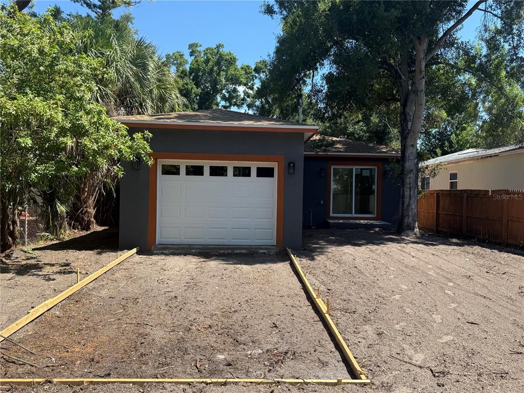 A gray house with a white garage door and wooden forms for a new driveway — 974 23RD AVENUE S, ST PETERSBURG, FL
