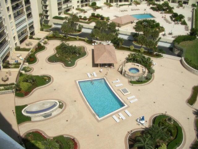 An aerial view of a resort-style pool deck featuring a rectangular pool, hot tub, and landscaping — 300 Ocean Trail Way # 1302, Jupiter FL 33477, JUPITER, FL