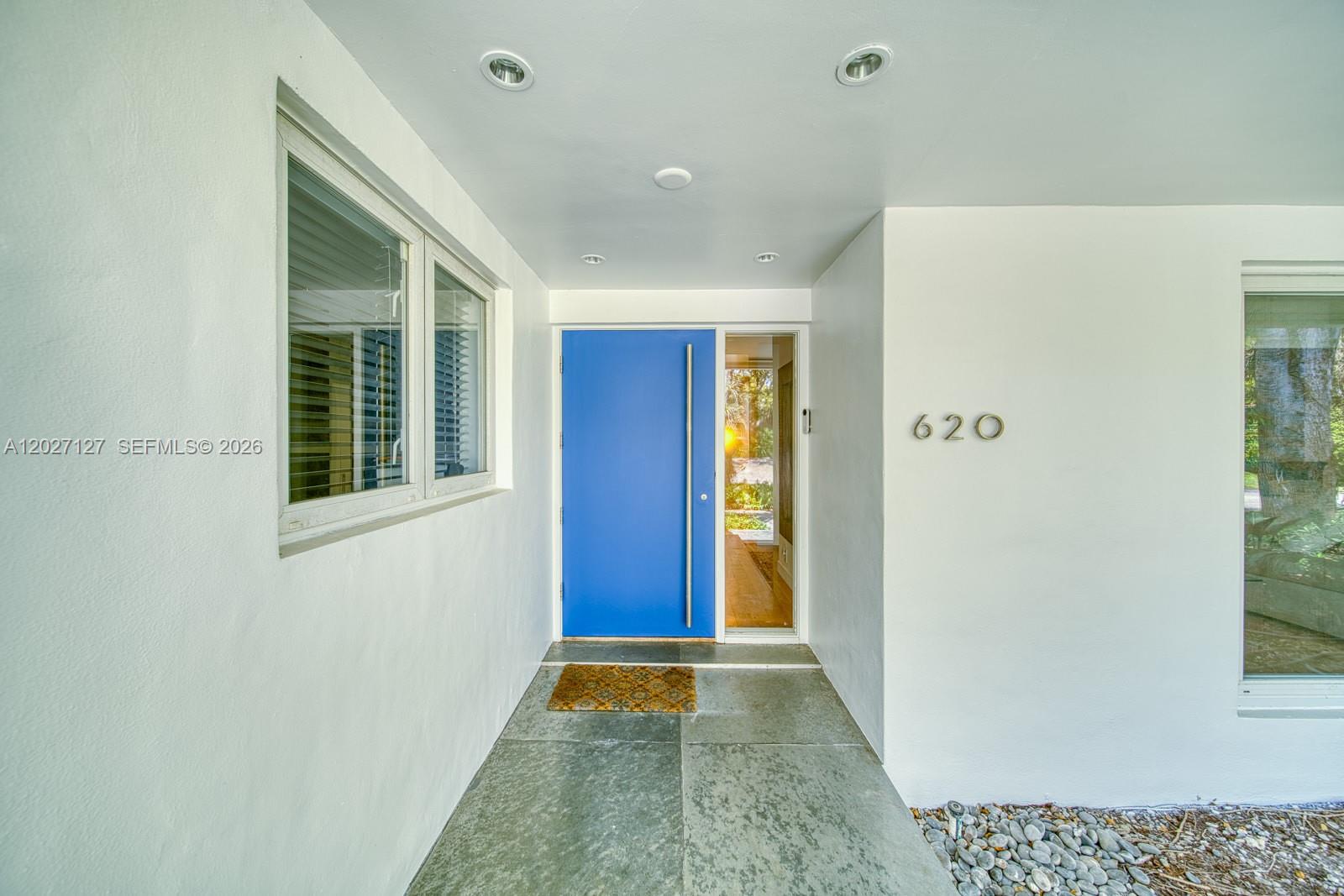 A bright blue front door with a vertical handle sits under a recessed porch — 620 Conde Ave, Coral Gables FL 33156, CORAL GABLES, FL