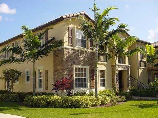 A two-story house with tan stucco, stone veneer accents, and palm trees in the front yard — 3360 NE 14th Dr # 30, Homestead FL 33033, HOMESTEAD, FL
