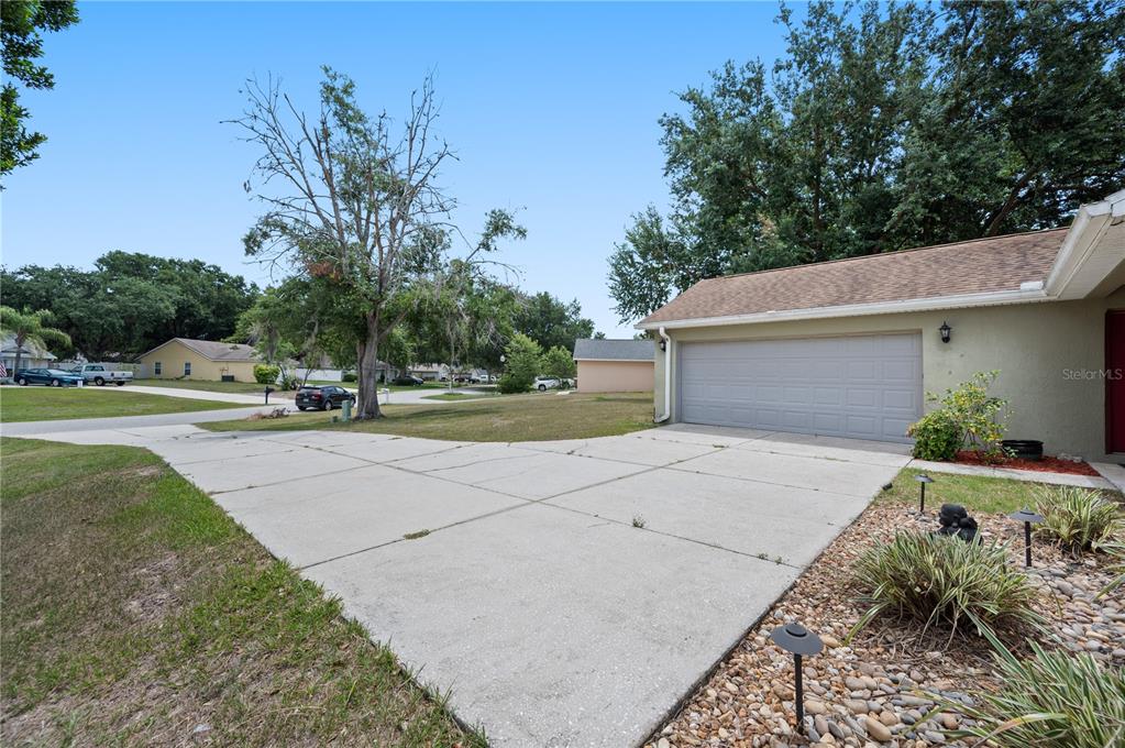 A concrete driveway leads to a two-car garage attached to a single-story house — 11724 CONSTANCE WAY, CLERMONT, FL