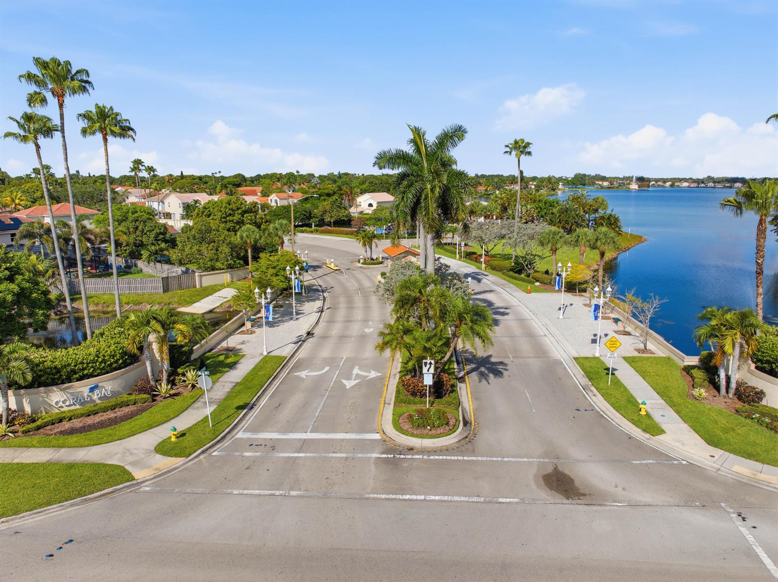 An aerial view of a road entrance to a residential community with palm trees — 6582 Bayfront Drive, Margate FL 33063, MARGATE, FL