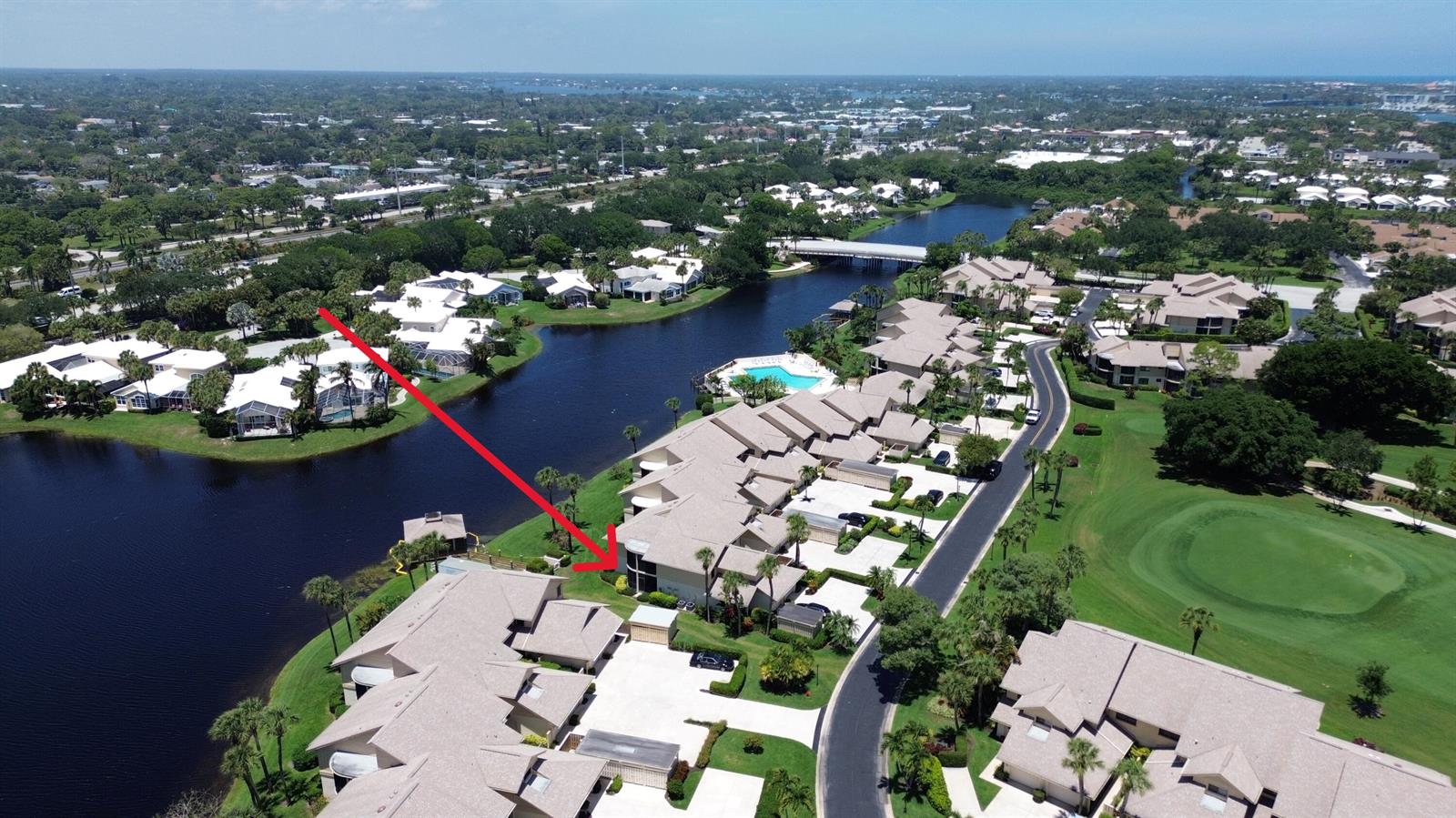 An aerial view shows a multi-unit residential complex with a red arrow pointing toward a unit — 16997 Waterbend Drive # 139, Jupiter FL 33477, JUPITER, FL