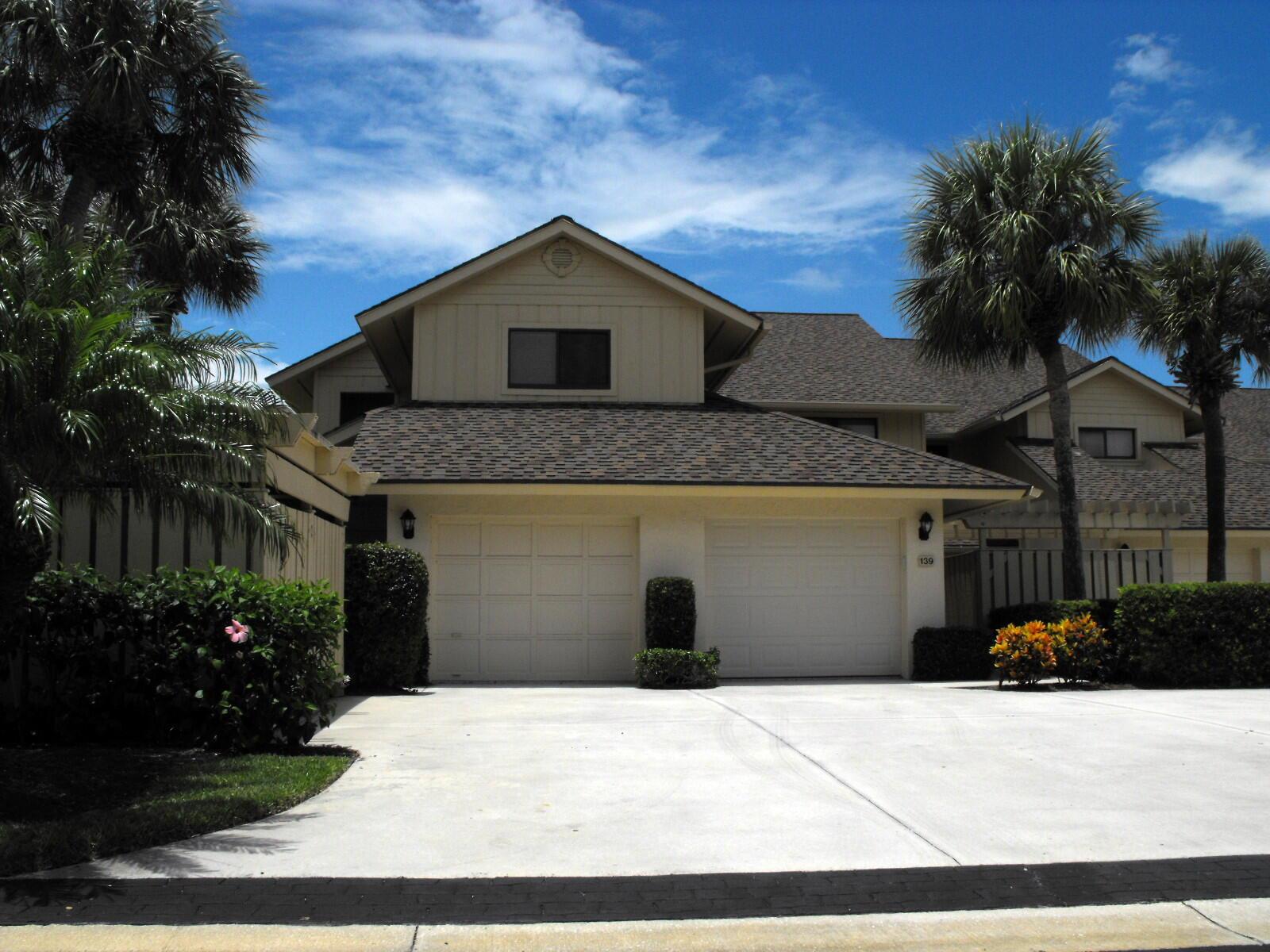 A two-story house with a two-car garage, palm trees, and a concrete driveway — 16997 Waterbend Drive # 139, Jupiter FL 33477, JUPITER, FL