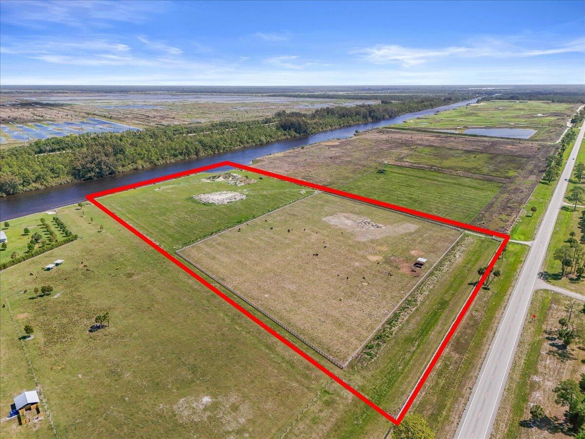 An aerial view shows a rectangular plot of land outlined in red beside a canal — 8105 SW Kanner Highway, FL 34956, FL