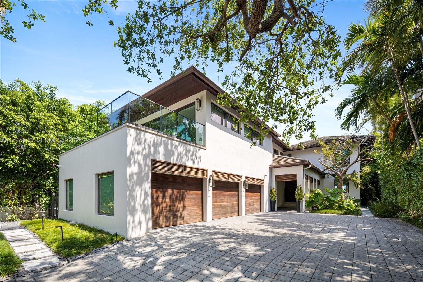 A modern two-story house with a three-car garage and a glass-railed balcony — 401 E Rivo Alto Dr, Miami Beach FL 33139, MIAMI BEACH, FL