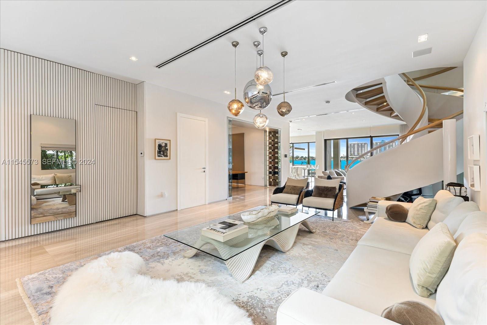 A modern living room features a glass coffee table, white sofa, and a spiral staircase — 401 E Rivo Alto Dr, Miami Beach FL 33139, MIAMI BEACH, FL