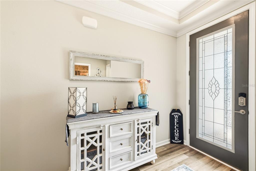 A white wooden console table sits in an entryway with a mirror and front door — 31 OLIVINE COURT, ST AUGUSTINE, FL