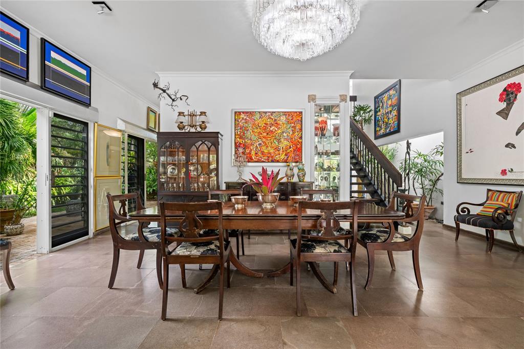 A dining room features a wooden table, chairs, a chandelier, and a staircase — 3 PEDROSA STREET GARDEN HILLS, GUAYNABO, PR