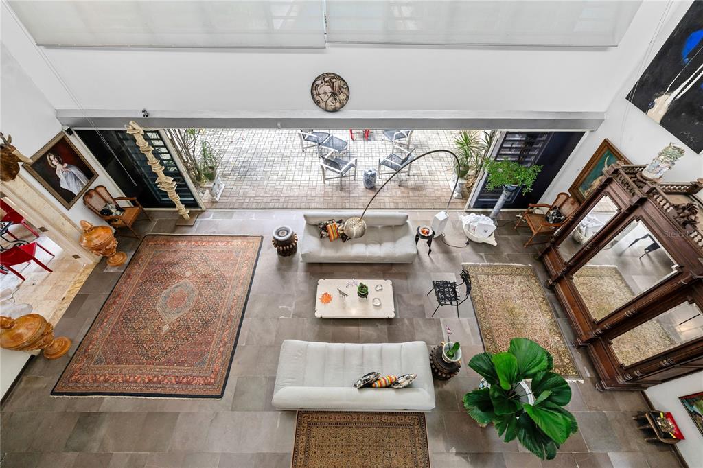 A high-angle view of a living room with stone floors, two sofas, and large glass doors — 3 PEDROSA STREET GARDEN HILLS, GUAYNABO, PR