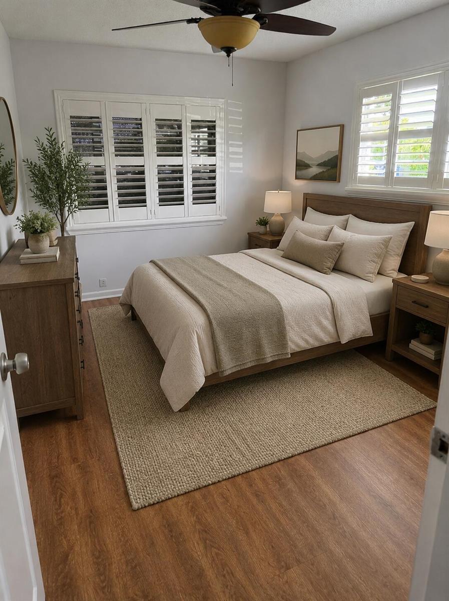 A bedroom features a wooden bed frame, neutral bedding, a jute rug, and plantation shutters — 434 Mansfield K, Boca Raton FL 33434, BOCA RATON, FL