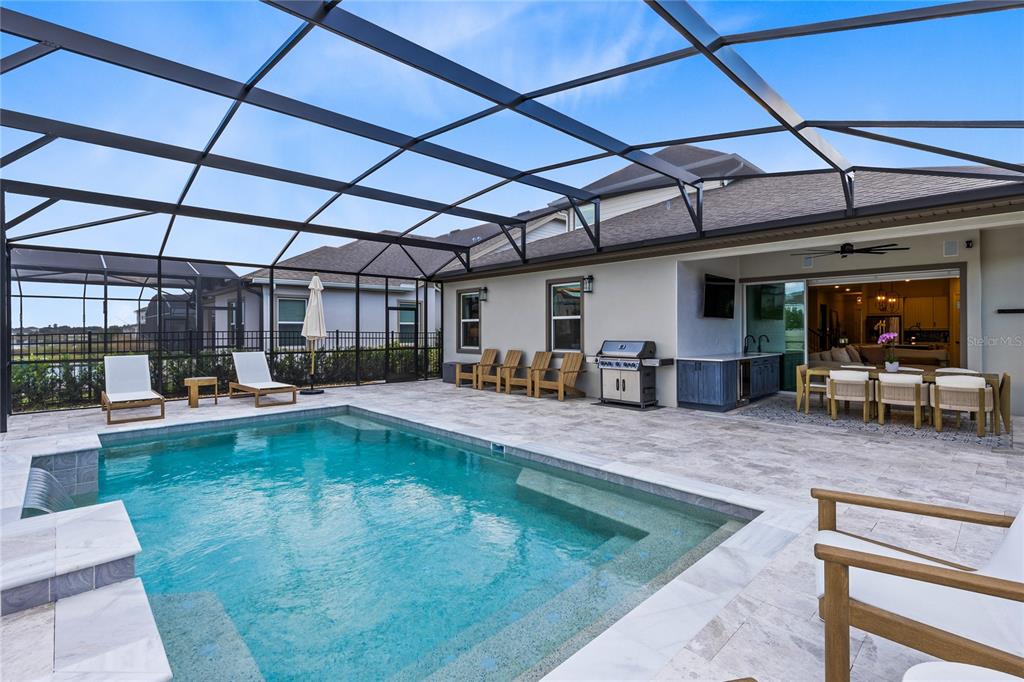 A screened-in patio features a swimming pool, outdoor kitchen, and dining area — 13373 MCMILLAN DRIVE, ORLANDO, FL