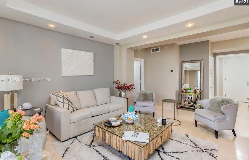 A living room features a beige sofa, a glass-topped wooden coffee table, and two armchairs — 888 Brickell Key Dr # 1004, Miami FL 33131, MIAMI, FL