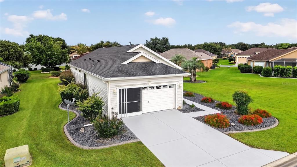 An aerial view of a single-story house with a white garage and a concrete driveway — 12771 SE 92ND TERRACE, SUMMERFIELD, FL