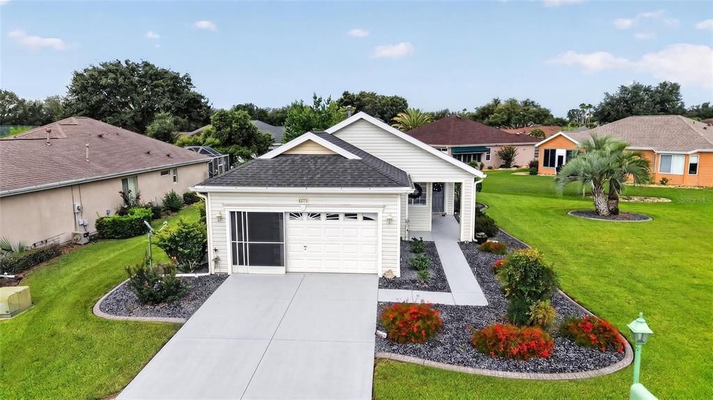An exterior view of a single-story house with a garage, driveway, and landscaped front yard — 12771 SE 92ND TERRACE, SUMMERFIELD, FL