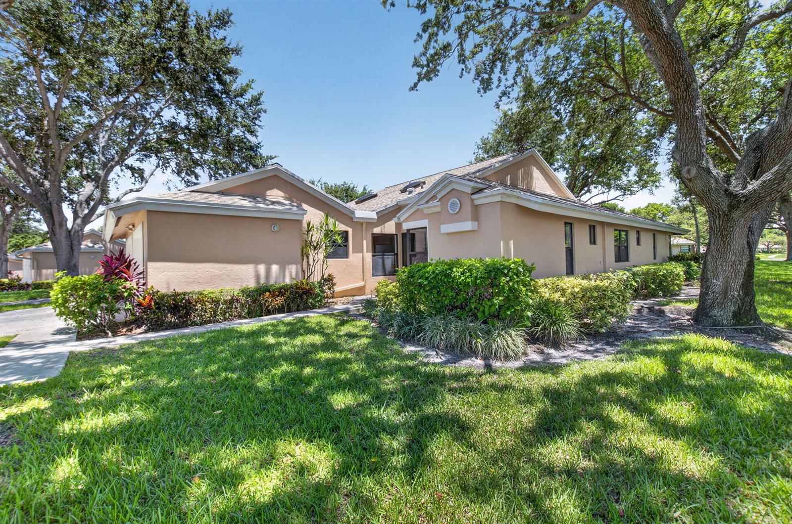 A single-story tan stucco house with a shingled roof surrounded by trees and landscaping — 8306 Summersong Terrace, Boca Raton FL 33496, BOCA RATON, FL